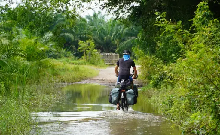 Fietsen door een plas water in Thailand